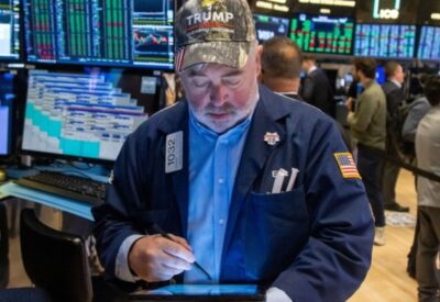 A trader wearing a Trump hat works on the floor of the New York Stock Exchange